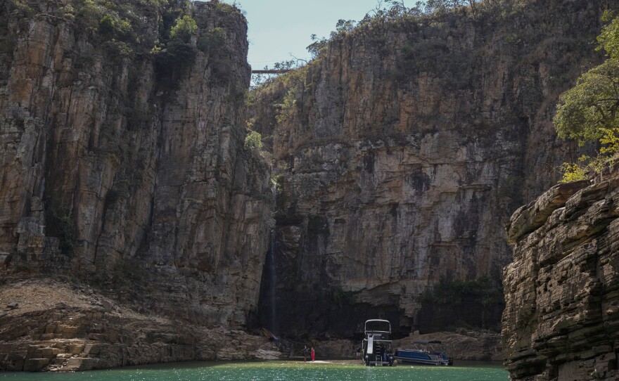 A tourist boat navigates through a canyon in Furnas Lake, near Capitolio City, Brazil, on Sept. 2, 2021. A massive slab of rock broke away on Saturday from the canyon wall and and toppled onto pleasure boaters killing at least six people and injuring dozens at the popular tourist destination in Minas Gerais state.