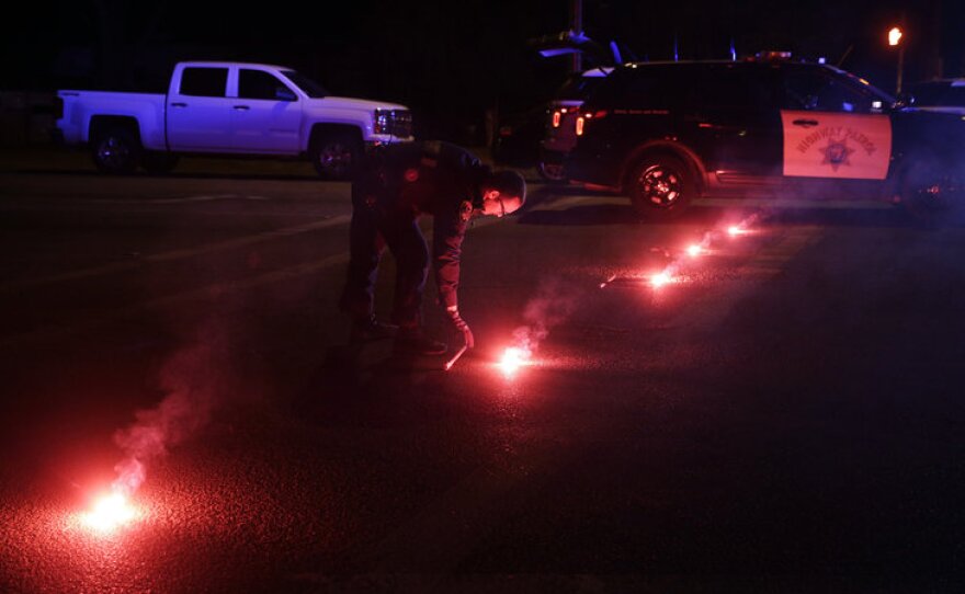 A police officer lights up flares near the scene of a shootout in San Bernardino, Calif., on Wednesday. Police say Syed Farook, 28, and Tashfeen Malik, 27, opened fire on an office holiday party in the Inland Regional Center.