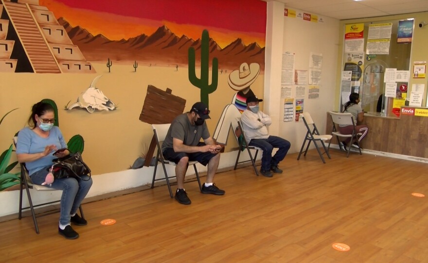 People waiting in line to wire money at a money transfer and shipping center in Oceanside. March 19, 2021.