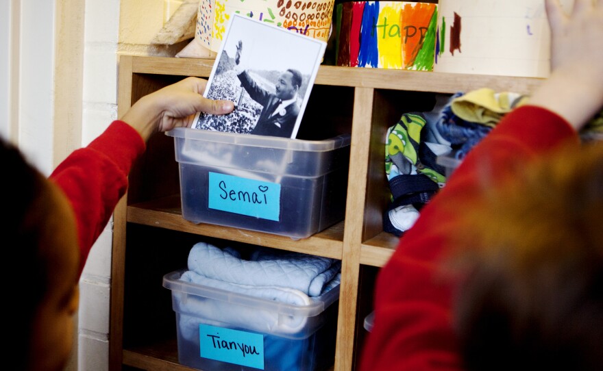 Semai Kebede shows off a photo of Dr. King he's keeping in his cubby. Barnhardt, who grew up in the segregated South, teaches her class about King's life and legacy, a history she's experienced firsthand.