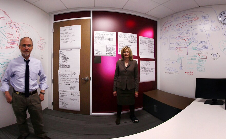 In this panoramic composite image, NPR's Peter Overby and Viveca Novak of the Center for Responsive Politics stand in front of a whiteboard at NPR headquarters that they used to map out connections between social welfare groups.