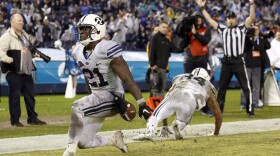 BYU running back Jamaal Williams, left, scores a touchdown against Wyoming during the second half of the Poinsettia Bowl NCAA college football game Wednesday, Dec. 21, 2016, in San Diego. 