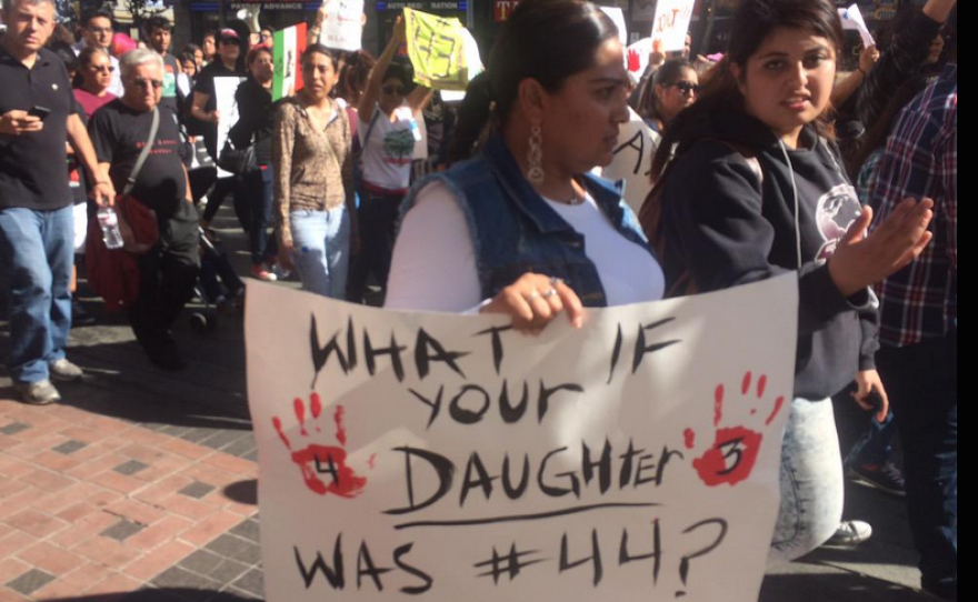 A protester, who is a part of a march in support of 43 missing Mexican students, is pictured carrying a sign that reads "What if your daughter was #44?" March 24, 2015.