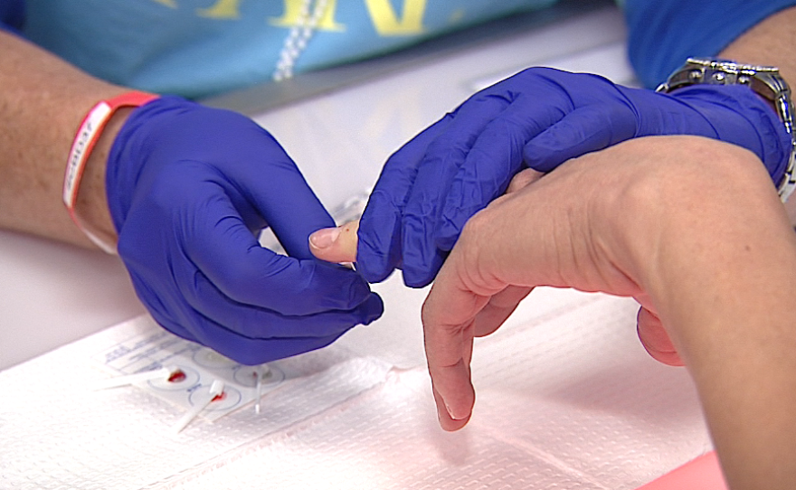 A woman gets her blood type analyzed at a blood drive where select participants received free genome sequencing, Nov. 24, 2015. 