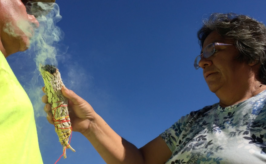An Indian woman cleanses a volunteer for Aguilas del Desierto with sage smoke, Sept. 17, 2016.