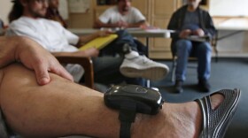In this photo taken Wednesday, Feb. 20, 2019, a GPS bracelet is seen on the ankle of an inmate attending a discussion about living in sobriety at the Male Community Re-entry Program in Oroville, Calif. California's attempt to ease prison inmates transition back into the community is coming at a price, as an increasing number of prisoners simply walk away. Facilities like the one in Butte County, and in similar programs elsewhere are lightly guarded and inmates wear GPS bracelets that show their locations.