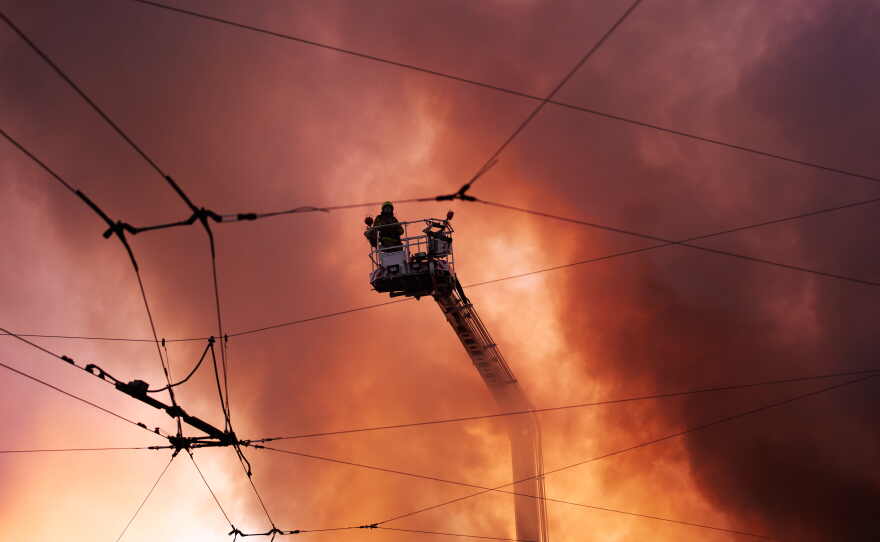 Firefighters try to put out a fire at a city book market following a Russian missile attack in Kyiv, Ukraine early Sunday, Aug. 16, 2026.