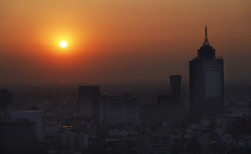 The sun rises over Mexico City on a smoggy morning, May 18.