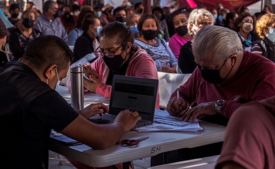 Mexicans hoping to fix incorrectly filled out vaccine proof cards talk with workers for the Secretaria de Bienestar, November 03, 2021.