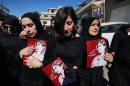 Mourners hold posters that show portraits of Lebanese journalist Amal Khalil, who was killed Wednesday in an Israeli airstrike, during her funeral procession in the village of Baysariyeh, in southern Lebanon, on Thursday.
