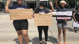 Howard University law students, from left, Chanel Sherrod, Domonique Dille and Temitope Aladetimi brought handmade signs to a protest near the White House last Saturday.