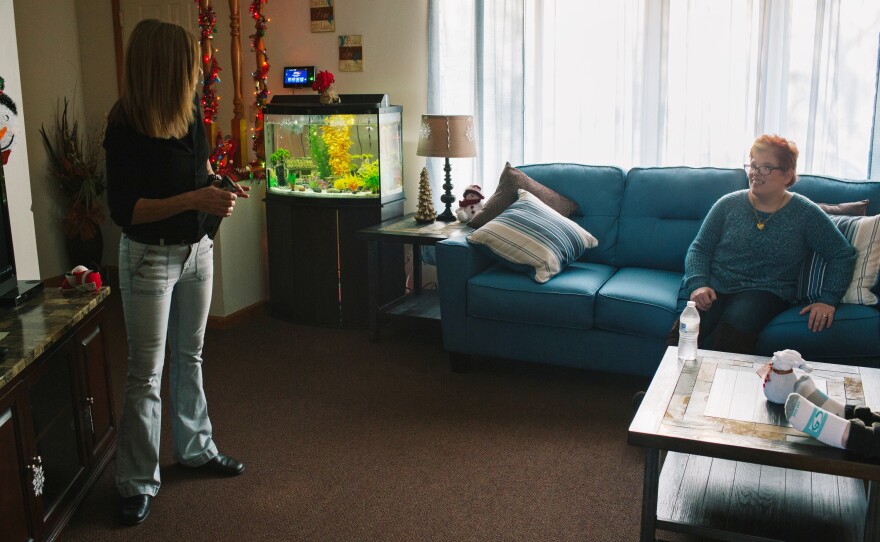 Roxanne Kiehart, one of the caretakers at Pauline's group home, puts in a movie for Pauline and a housemate after they returned home from a day program.