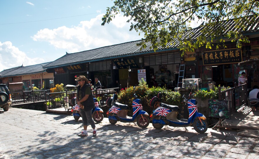 Electric scooters for rent sit outside a row of restaurants near Lugu Lake. Renting real estate for out-of-town businessmen to run inns and restaurants on is a major source of income for Mosuo residents around the lake.