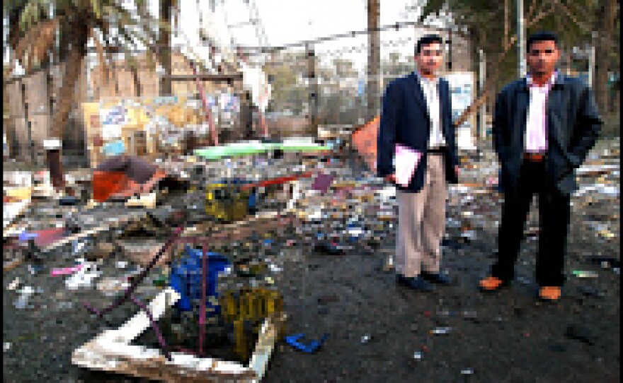 Students look at the scene of explosions in front of al-Mustansiriyah University, where dual bombings were timed to the end of the school day.