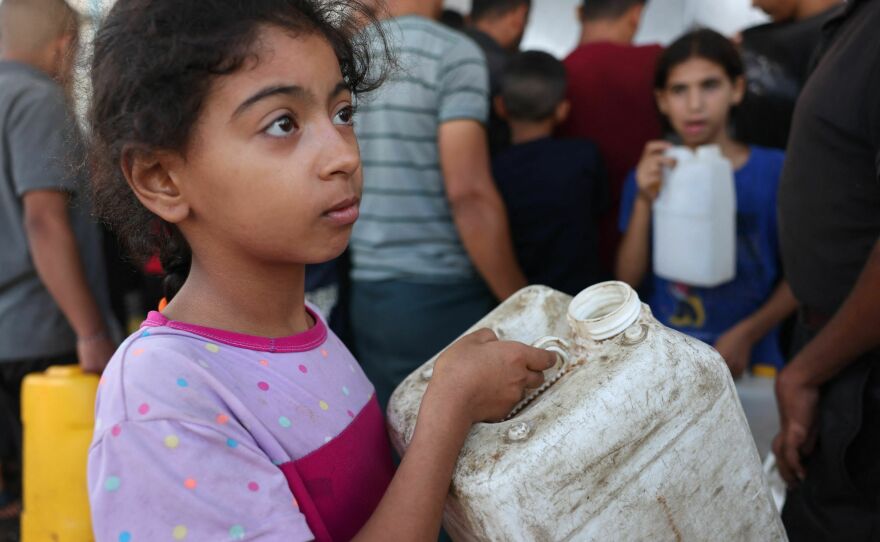 A Palestinian girl holds a container as she waits to collect portable water, in Khan Yunis, in the southern Gaza Strip on Oct. 26, 2023, amid the ongoing battles between Israel and the Palestinian group Hamas.