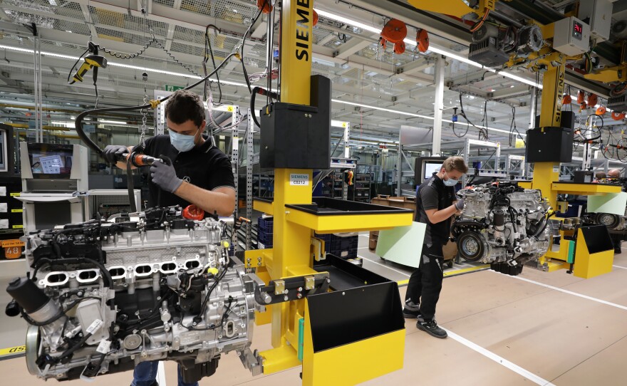 Employees assemble motors at a Mercedes-Benz factory in Stuttgart, Germany, on Wednesday. The German government pays much of laid-off workers' salaries for up to 12 months during economic crises.