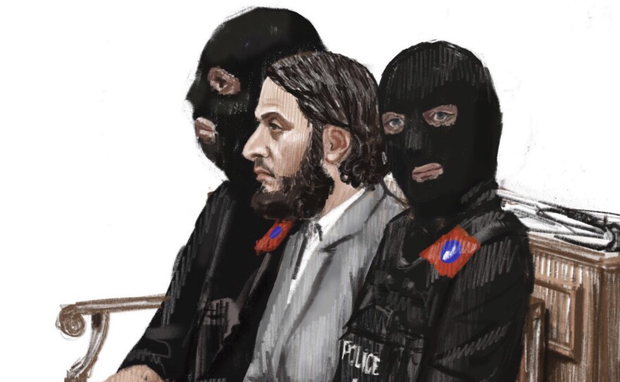 In this courtroom sketch, Salah Abdeslam (center) sits between two police officers at the Brussels Justice Palace in February. He was sentenced Monday to 20 years in prison over charges related to a shootout when he resisted arrest months after the 2015 Paris attacks.