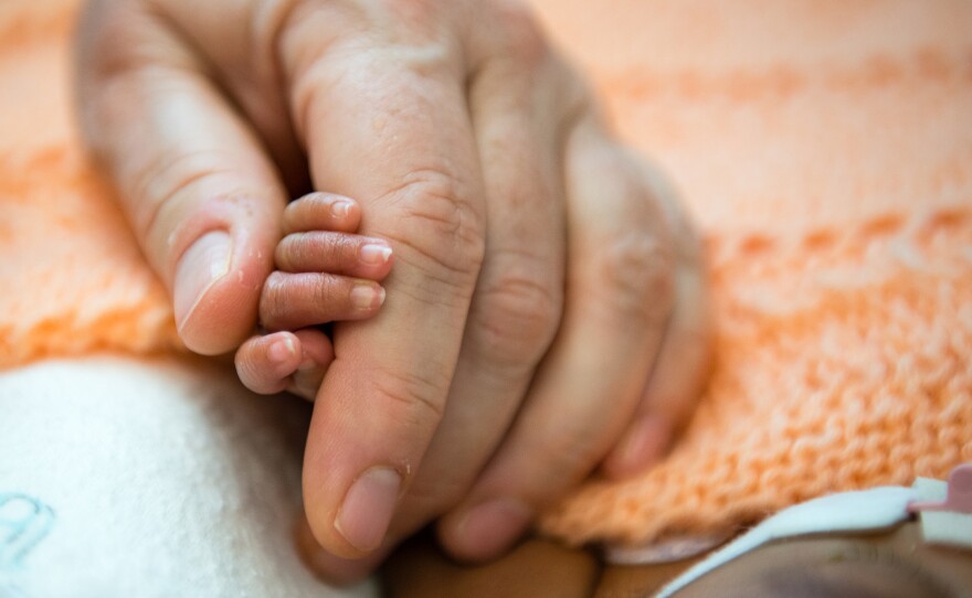 Kate Teague, a registered nurse at Lucile Packard Children's Hospital, in Palo Alto, Calif., holds a premature baby's hand.