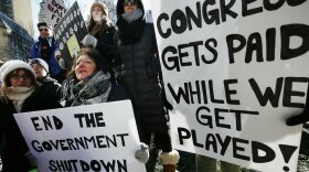 Government workers and their supporters hold signs during a protest in Boston, Friday, Jan.11, 2019. The workers rallied with Democratic U.S. Sen. Ed Markey and other supporters to urge that the Republican president put an end to the shutdown so they can get back to work.