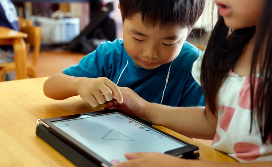 FILE - Children work on a digital program at Coby Preschool in Yoshikawa, suburban Tokyo, July 12, 2018. (AP Photo/Yuri Kageyama, File)