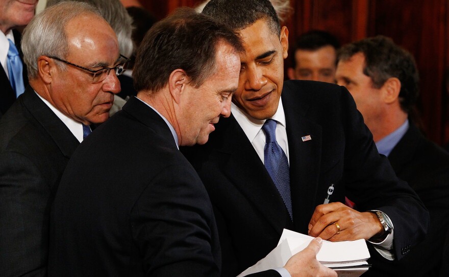 President Obama signs a copy of the Affordable Care Act for a member of Congress after signing the actual bill during a ceremony in the East Room of the White House on March 23, 2010, in Washington, D.C.