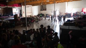 Dozens of people wait in line for a clothing donation distribution at the Templo Embajadores de Jesús shelter in Tijuana, June 1, 2022.