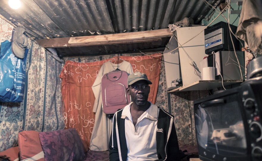 Ishmae Uchani, 47, in his one-room home in the township of Masiphumelele in Cape Town. Uchani shares his house, which measures approximately 6 feet by 10 feet, with his wife and two children. He says the government's orders to stay at home during the coronavirus lockdown are unworkable. Uchani was a day laborer in the construction industry before the lockdown and has now lost his income.