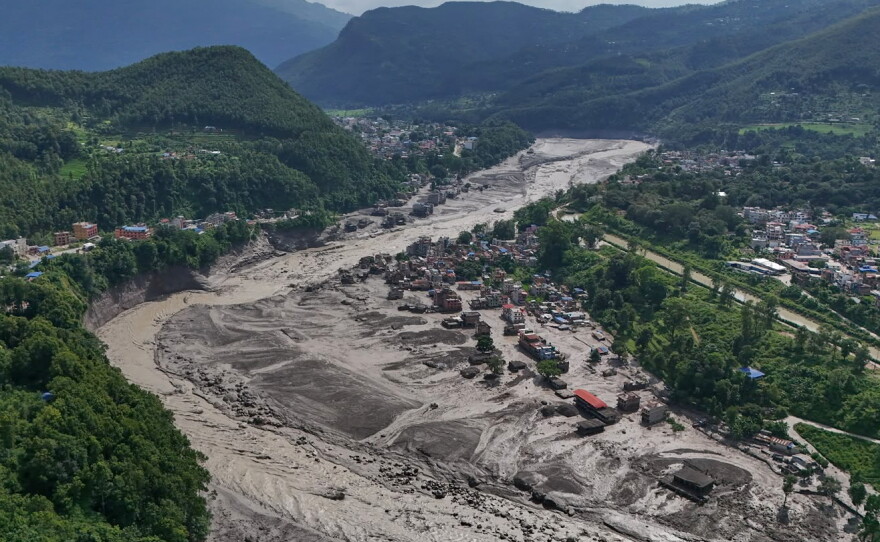 Damaged houses stand precariously near the swollen, debris-choked banks of the Trishuli River after flash floods in Nepal's Nuwakot district on Wednesday.