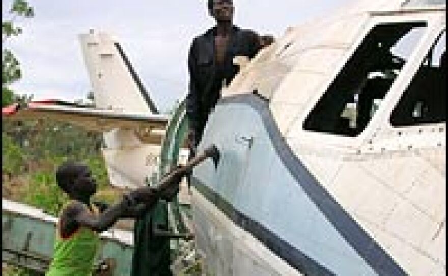 Workers at an airstrip in Rumbek, in South Sudan, hack apart the fuselage of an old transport plane with axes. Later the aluminum will be recycled into cooking pots.