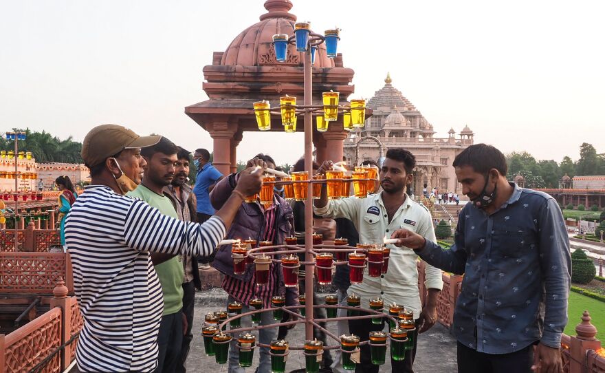 People light oil earthen lamps on the eve of Diwali at the Akshardham Hindu temple in Gandhinagar, India, on Wednesday.