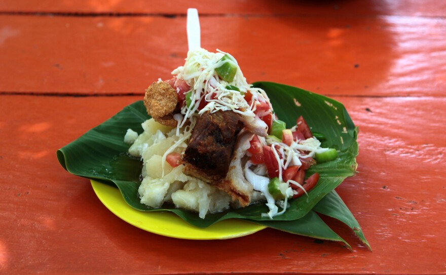 Vigorón served at El Gordito in Granada, Nicaragua. The combination of soft, starchy yucca; salty, rough pork cracklings; and tangy, cool slaw made with cabbage, onions, tomato, mimbre fruit (also known as mimbro), chile and vinegar offers a distinct interplay of textures and flavors.