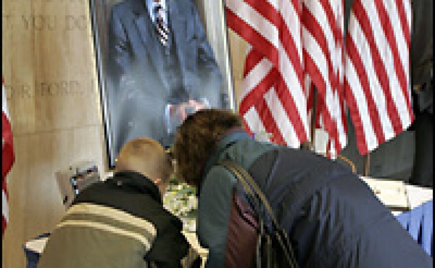 Anne Marie Brown and her son Thomas, age 7, of Holland, Mich., sign the condolence book in memory of President Gerald Ford on Wednesday at the Gerald R. Ford Museum in Grand Rapids, Mich.
