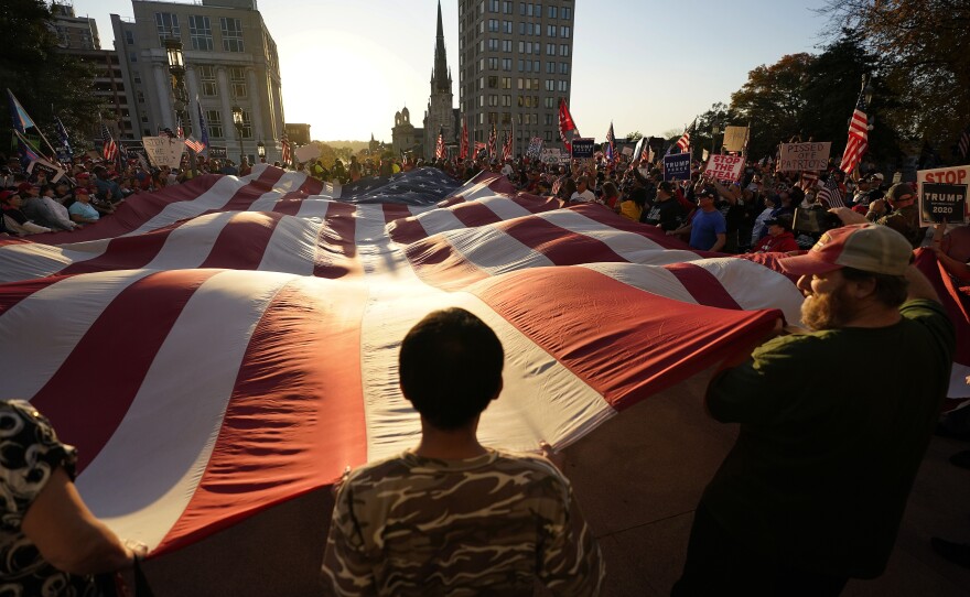 HARRISBURG: Supporters of President Donald Trump unfurl a giant American flag outside the Pennsylvania State Capitol, Saturday, Nov. 7, 2020, in Harrisburg, Pa., after Democrat Joe Biden defeated Trump to become 46th president of the United States.