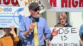 Craig Rose, director of Public Power San Diego, advocates for a nonprofit, publicly owned utility company outside of the headquarters for SDG&E's parent company on Thursday, Feb. 26, 2026.