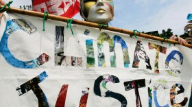 Masked activists hold banners during a protest Oct. 2 outside the U.N. regional office in Bangkok, where delegates held talks on climate change.