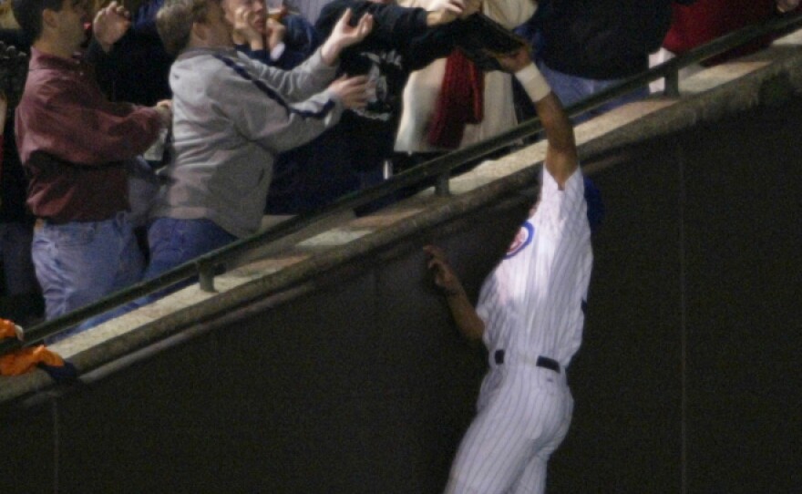 <p>As the Chicago Cubs' Moises Alou made a leaping attempt at a pop foul during the National League Championship Series, Steve Bartman (in Cubs cap and dark sweater) was among the fans reaching for the ball. While one image suggests he acted alone, the second photo tells another story.</p>
