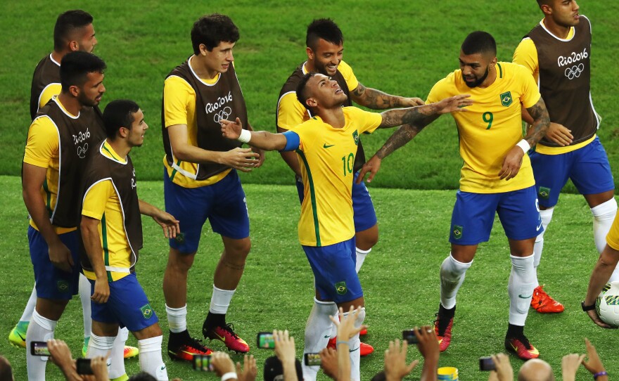 Neymar of Brazil is surrounded by teammates as he celebrates scoring the first goal in the men's soccer final against Germany at Rio's Maracana Stadium. Neymar made the crucial penalty kick that won the game for Brazil.
