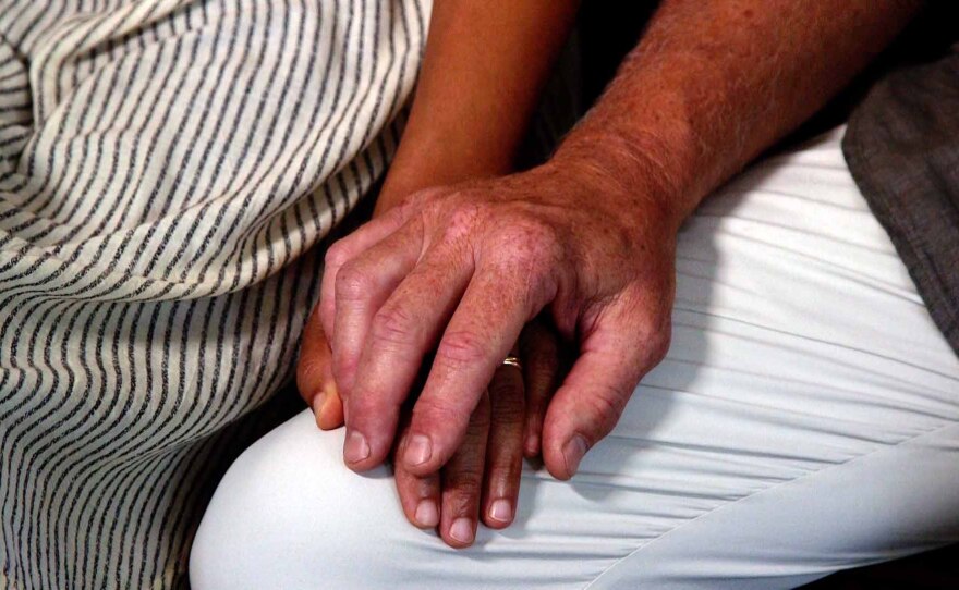 Kyona Beatty and Ken Zak hold hands in their Mission Hills' home. 