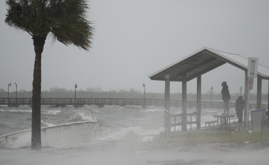 People brave rain and heavy winds to visit the waterfront along the Jensen Beach Causeway, as conditions deteriorate with the approach of Hurricane Nicole, Wednesday, Nov. 9, 2022, in Jensen Beach, Fla.