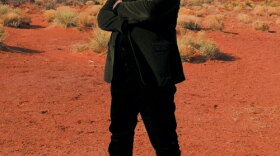 Stephen Fry stands with the desert in the background along his journey across the United States. 