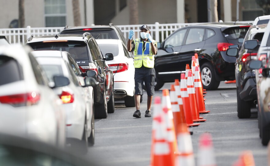 A public safety officer directs drivers where to go last week at a coronavirus testing site at the Lee Davis Community Resource Center in Tampa, Fla.