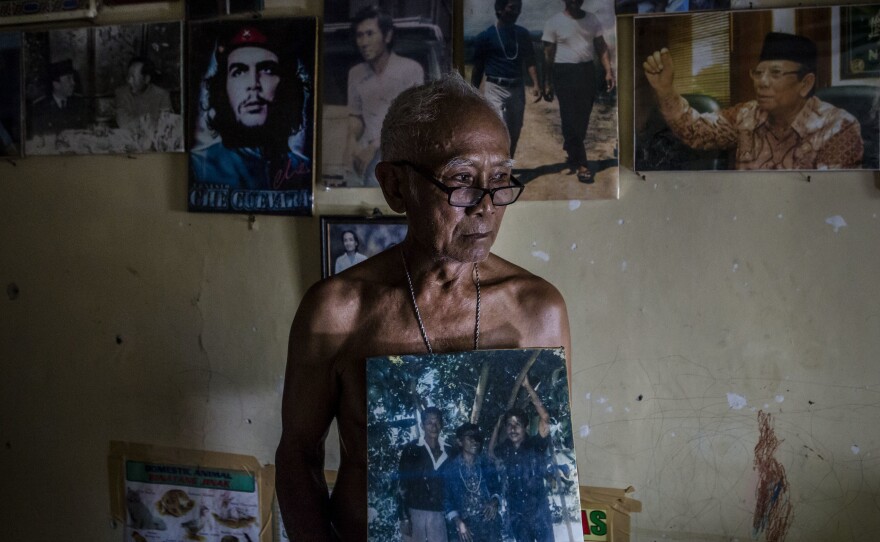 A former prisoner holds a photo of his fellow inmates during his 14-year imprisonment for suspected communist ties.