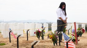 Witchelda Bondoc stands over her husband Joseph Bondoc's grave at Miramar National Cemetery on June 30, 2020. Bondoc died from COVID-19 in May. 