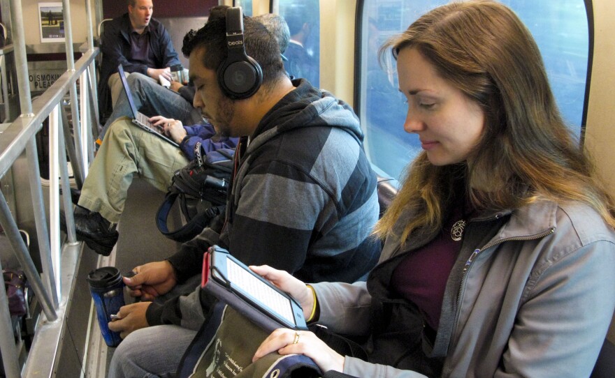 Kathy LeVeque reads her tablet on her reverse commute from her city home to her job in north suburban Deerfield.