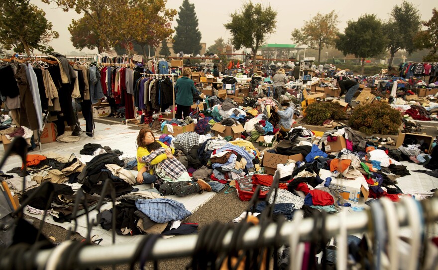 An evacuee of the Camp Fire pauses to hug her son as they volunteer sorting clothes at a makeshift shelter in Chico, Calif.