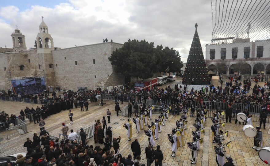 Palestinian scout bands parade through Manger Square at the Church of the Nativity, traditionally believed to be the birthplace of Jesus Christ, during Christmas celebrations, in the West Bank town of Bethlehem on Friday.
