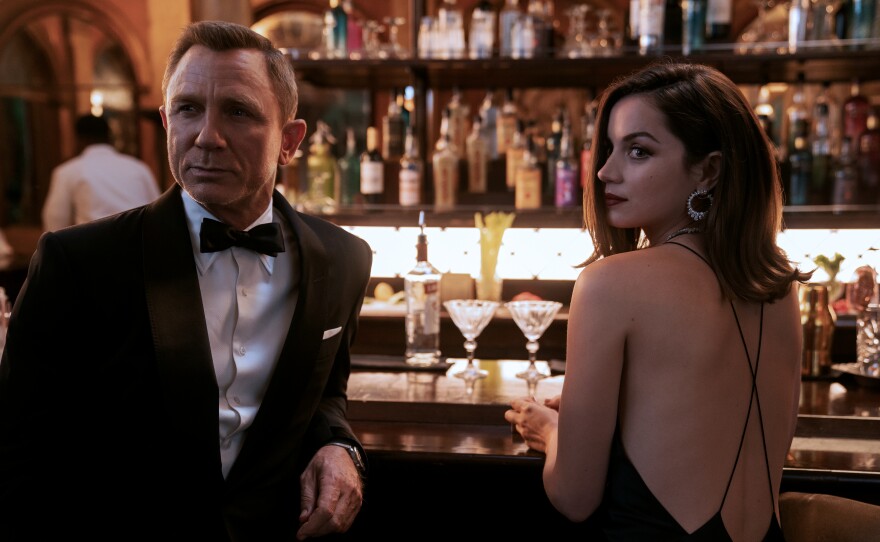 "No Time To Die" gives us some of the expected 007 trappings — Bond in a tux, sexy women — but with a twist. Here James Bond (Daniel Craig) meets Paloma (Ana de Armas).