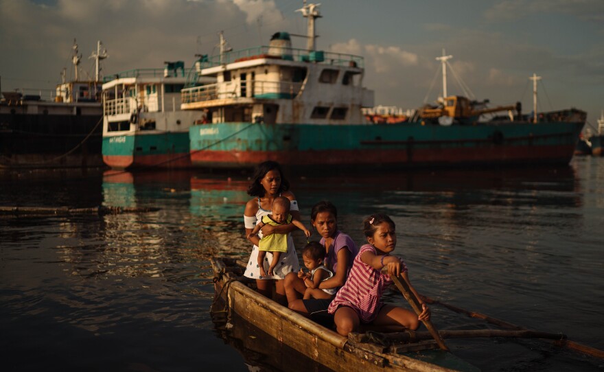 Sisters Joan (center) and Jossa Garcia (left), both teen mothers, hang out in a boat with their children and their younger sister. Each year, 1.2 million Filipina girls between the ages of 10 and 19 have a child.