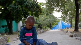 A young boy plays with stones earlier this week at an orphanage in Port-au-Prince. He was among the group of 33 Haitian children that 10 American church workers tried to take across the border into the Dominican Republic.