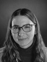Image of woman with eyeglasses smiling at camera
